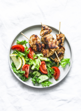 Turkey skewers and vegetables fresh salad on a light background, top viewの写真素材