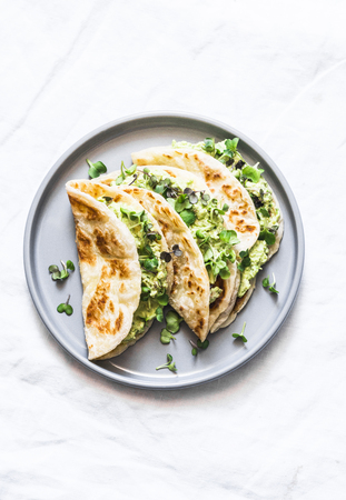 Avocado eggs greens salad paratha flatbread quesadilla on a light background, top viewの写真素材