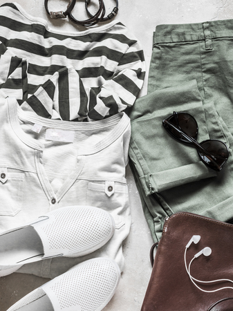 Spring summer set of women's casual wear - cotton pants, white t-shirt, striped pullover, leather sneakers, bag and accessories on a light background, top view. Fashion conceptの写真素材