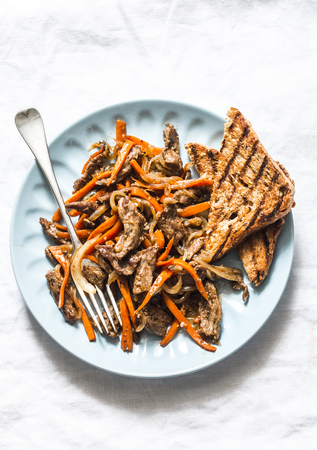 Spicy fried beef wok with carrots on a light background, top viewの写真素材