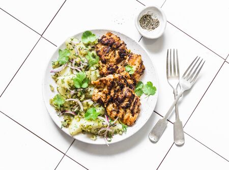 Delicious lunch - grilled chicken fillet and  dill, cilantro new potatoes salad on light background, top viewの写真素材