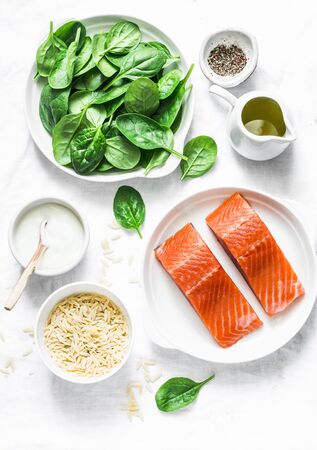 Ingredients for a balanced lunch - salmon fish, spinach, cream, orzo pasta on a light background, top viewの写真素材