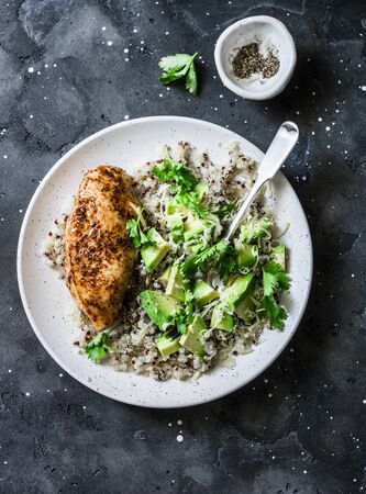 Quinoa, roasted chicken breast, avocado, cheese, cilantro bowl on dark background, top view. Healthy eating conceptの写真素材