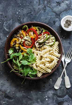 Fried vegetables and fusilli pasta antipasti salad on dark background, top viewの写真素材