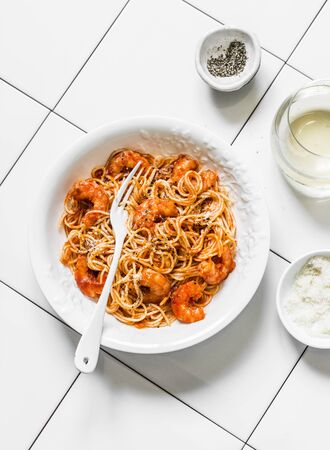 Prawns tomato sauce spaghetti and white wine on a light background, top viewの写真素材