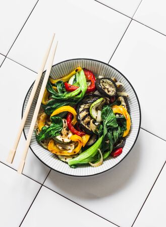 Stir fry vegetables in asian style. Quickly roasted wok vegetables - bok choy, eggplant, bell pepper, zucchini on a light background, top viewの写真素材