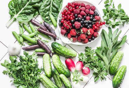 Fresh natural organic products - vegetables, herbs, berries on a light background, top view. Flat...