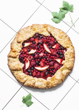 Mixed berries summer pie on a light background, top view. Red, black currant, strawberry, raspberry sweet pieの写真素材