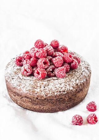 Chocolate nut cake with raspberry on light background. Delicious dessertの写真素材