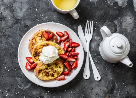Baked french toast with ice cream and strawberries on a dark background, top view. Delicious breakfast, dessert, snack.Flat layの写真素材