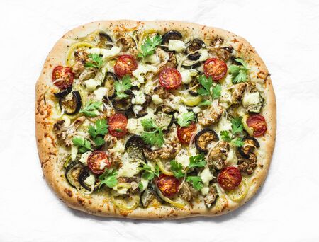 Baked vegetables vegetarian flatbread on a light background, top view. Cauliflower, eggplant, tomato, zucchini vegetarian pizzaの写真素材