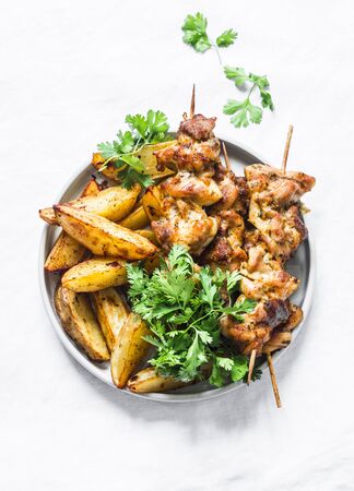 Pork skewers kebab with baked potatoes on a light background, top view. Delicious tapasの写真素材