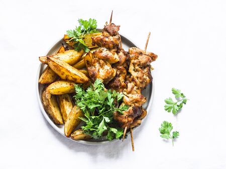 Pork skewers kebab with baked potatoes on a light background, top view. Delicious tapasの写真素材