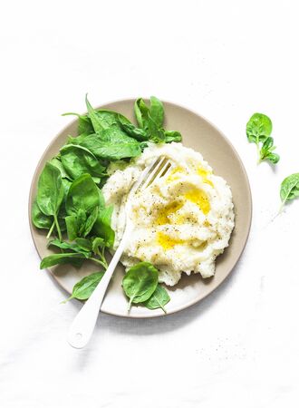 Cauliflower mashed with spinach. Delicious vegetarian lunch or garnish on a light background, top viewの写真素材