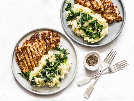 Turkey grilled chop and mashed potatoes with creamy spinach on a light background, top view. Comfort home cooked foodの写真素材