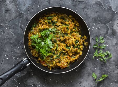Eggplant spinach vegetarian curry in a pan on a dark background, top view. Indian cuisineの写真素材