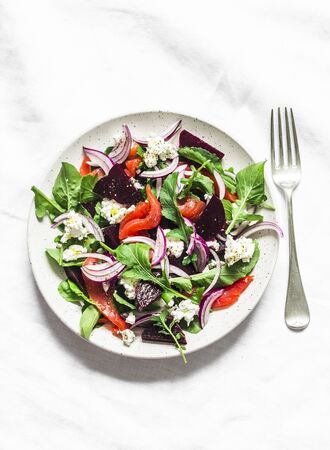 Beetroot, smoked salmon, arugula, soft cheese salad on a light background, top viewの写真素材