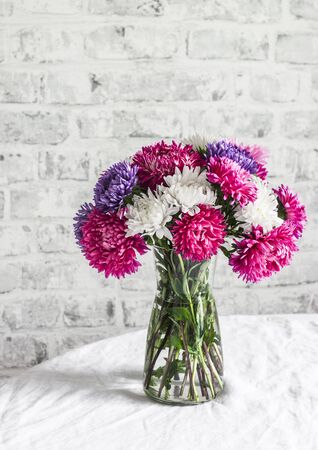 Bouquet purple aster flowers on the kitchen table on a light background. Cozy home conceptの写真素材