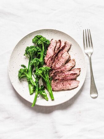 Fitness diet healthy lunch - grilled beef steak and boiled broccoli on a light background, top viewの写真素材