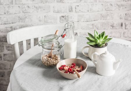 Delicious healthy breakfast - granola with fresh berries and coconut milk on a light background. Flat layの写真素材