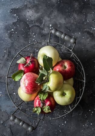 Fresh ripe apples in a metal vintage basket on a dark background, top viewの写真素材