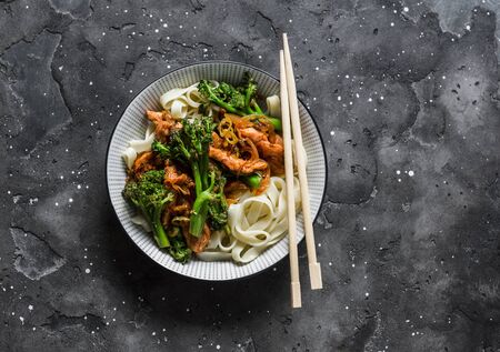 Teriyaki stir fry chicken with broccoli and noodles on dark background, top view. Asian style foodの写真素材