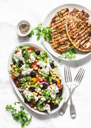 Mediterranean style lunch table - Greek chickpeas salad and pork chops on light background, top viewの写真素材