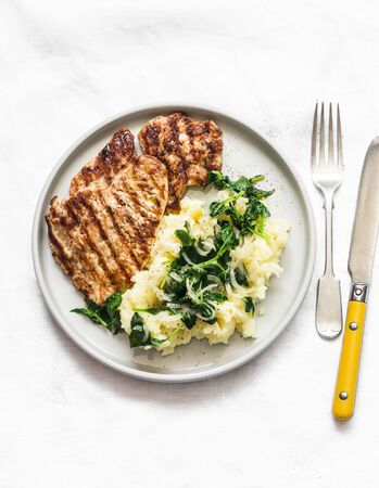 Turkey grilled chop and mashed potatoes with creamy spinach on a light background, top viewの写真素材
