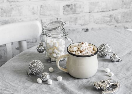 Hot chocolate with marshmallow - traditional Christmas winter warming drink on the bright kitchen table surrounded by Christmas decorations. Christmas mood inspirationの写真素材