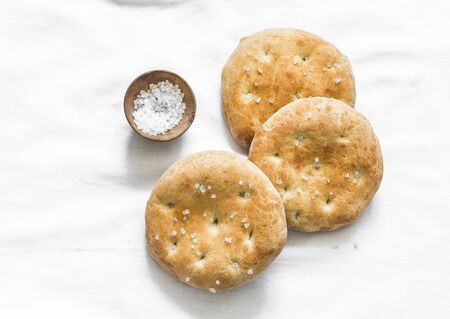 Small focaccia tortillas with sea salt on a light background, top viewの写真素材