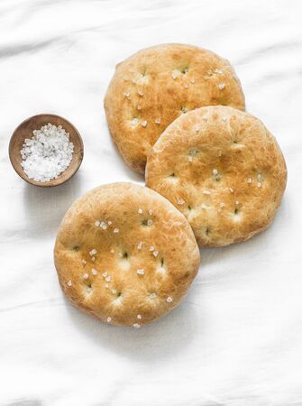 Small focaccia tortillas with sea salt on a light background, top viewの写真素材