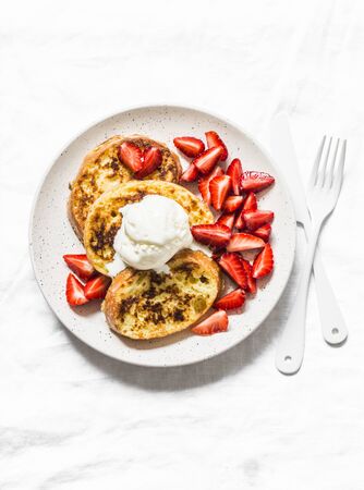 French toast with ice cream and strawberries on a light background, top view. Delicious breakfast, dessert, snackの写真素材