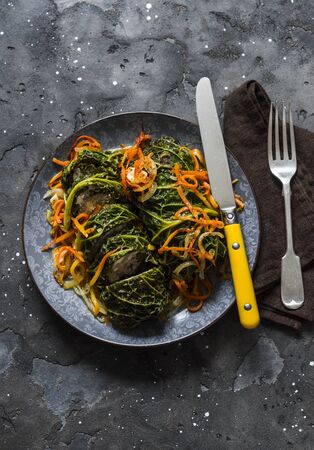 Vegetarian delicious lunch - baked savoy cabbage stuffed with spicy bulgur on a dark background, top viewの写真素材