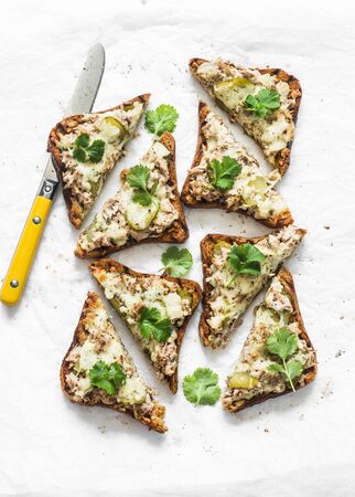 Pickles gherkins, canned tuna, cheese, multigrain bread baked sandwiches on a light background, top viewの写真素材