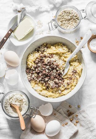 Cooking banana oatmeal cake with white and milk chocolate. Ingredients for the cake on a light background, top view. Flat layの写真素材