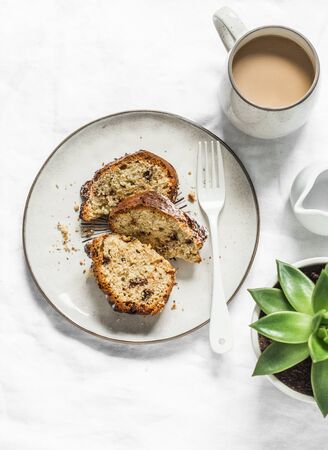 White and milk chocolate banana oatmeal cake, coffee, succulent flower on a light table background, top view. Delicious breakfast, snack, dessertの写真素材