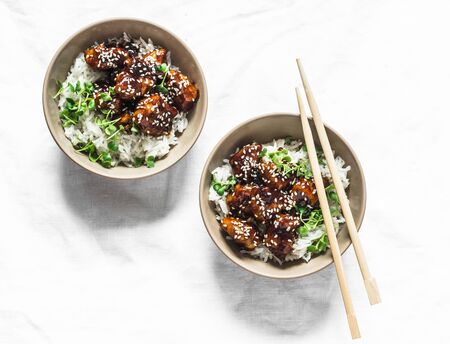 Teriyaki sauce juicy chicken cubes with rice and micro greens - delicious asian style lunch on white background, top viewの写真素材