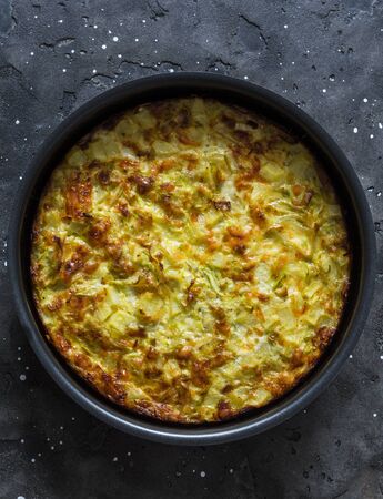 Leeks, potatoes, zucchini frittata on a dark background, top view. Delicious appetizer, tapas, breakfastの写真素材