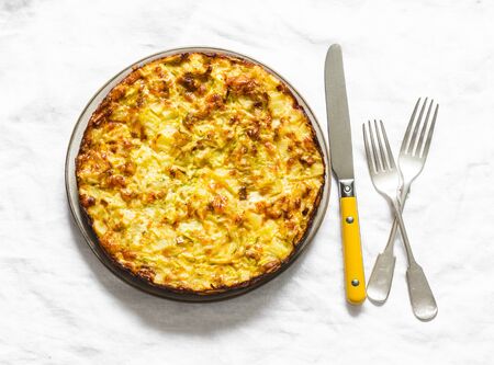 Leeks, potatoes, zucchini tortilla on a light background, top view. Delicious appetizer, tapas, breakfastの写真素材