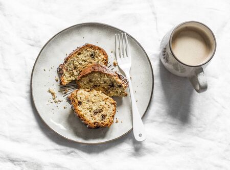 Slice of banana oatmeal chocolate cake and coffee on a light background, top view. Delicious breakfast, snack, dessertの写真素材