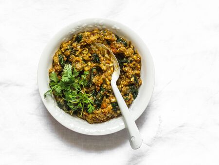 Aubergine spinach vegetarian curry on a light background, top view. Indian cuisineの写真素材