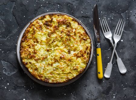 Leeks, potatoes, zucchini tortilla on a dark background, top view. Delicious appetizer, tapas, breakfastの写真素材