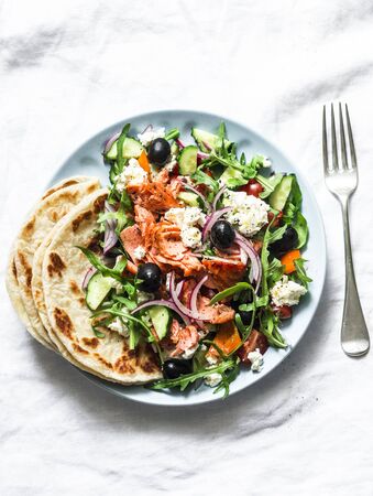 Smoked trout greek salad on a light background, top view. Healthy mediterranean diet foodの写真素材