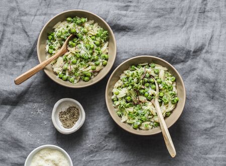 Green peas, spring herbs orzotto on a gray background, top view. Vegetarian food conceptの写真素材