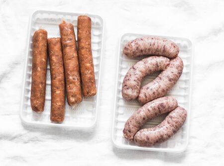 Raw uncooked turkey and spicy smoked paprika pork homemade sausages on light background, top view. Food ingredientsの写真素材