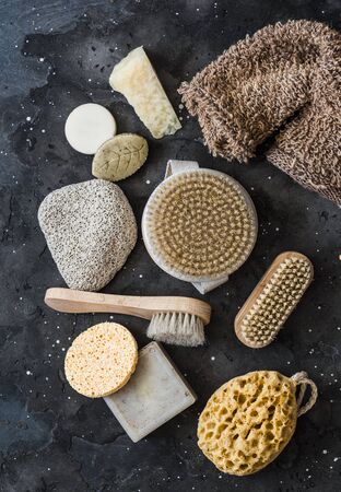 Body skin care. Brushes with natural bristles, pumice, homemade soap, sponge on a dark background, top viewの写真素材