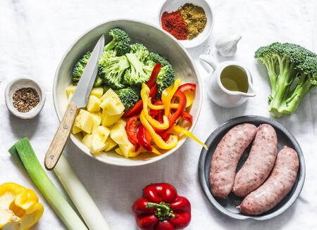 Ingredients for comfort  lunch - turkey sausages, potatoes, broccoli, sweet peppers, spices on a light background, top viewの写真素材