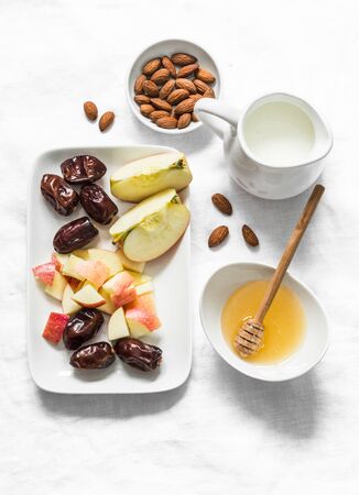 Ingredients for honey almonds apples protein smoothies on a light background, top view. Dates, almond milk, dates, honey, almonds - ingredients for a healthy diet drinkの写真素材