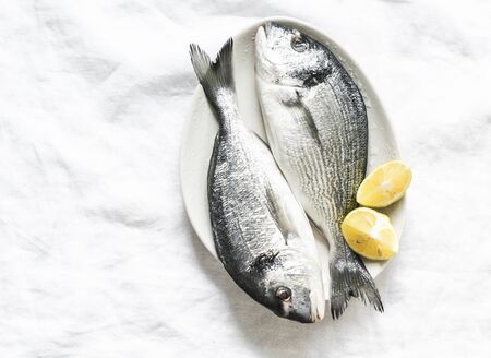 Fresh raw organic dorado on light background, top view. Food ingredientsの写真素材