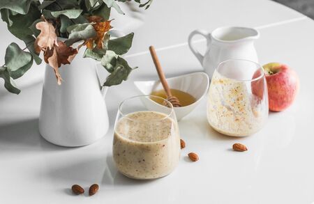 Honey, almonds, dates, apples, almond milk protein smoothies on a light table. Healthy diet protein drinkの写真素材